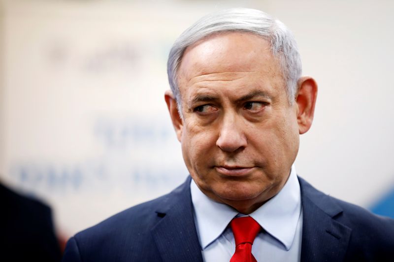 Israeli Prime Minister Benjamin Netanyahu looks on as he delivers a statement during his visit at the Health Ministry national hotline, in Kiryat Malachi, Israel