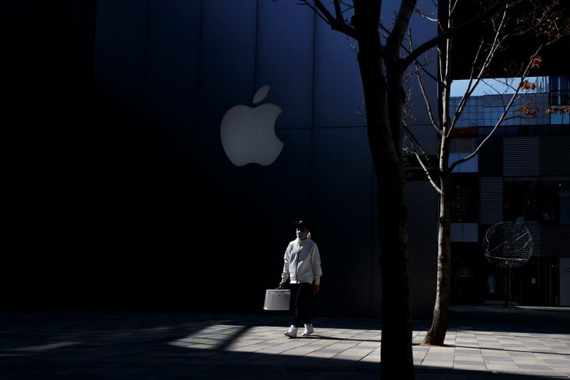 A man wearing a face mask walks past an Apple store in an upmarket shopping district in Beijing as the country is hit by an outbreak of the novel coronavirus