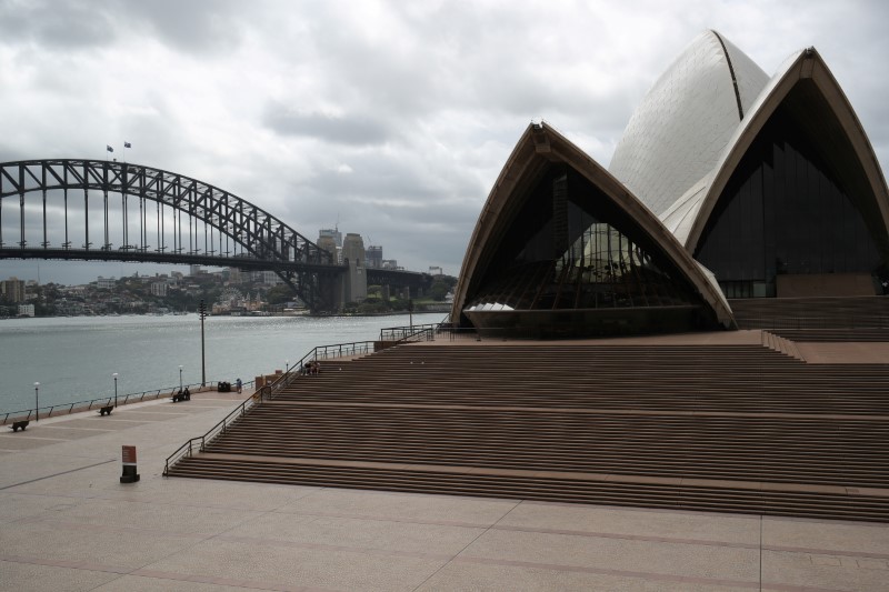 People are seen on the nearly deserted steps of the Sydney Opera House