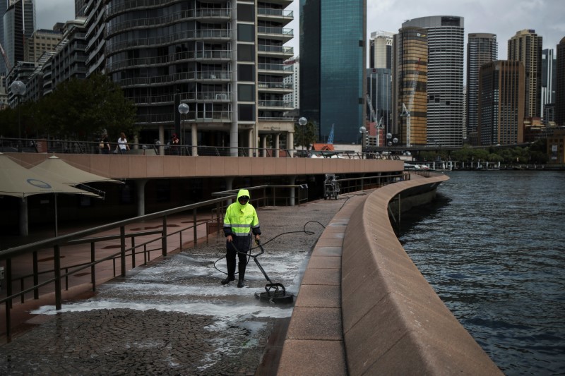 A worker cleans the waterfront area of the Sydney Opera House