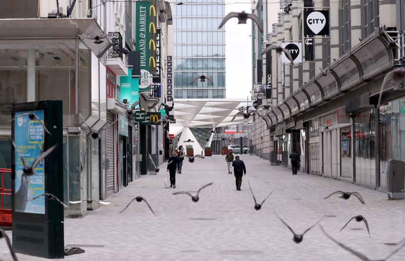 People walk along an almost empty shopping street, while Belgian government imposed a coronavirus lockdown in an attempt to slow down the coronavirus disease (COVID-19), in Brussels