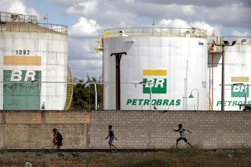 FILE PHOTO: People past in front of the tanks of Brazil's state-run Petrobras oil company in Brasilia