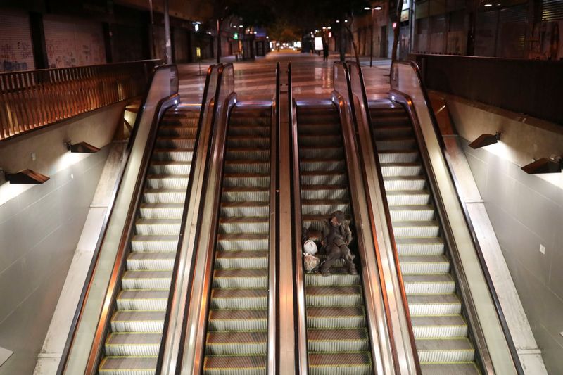 A homeless man sleeps on an escalator during a preventive quarantine following the outbreak of coronavirus disease (COVID-19)