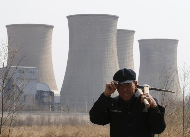 A worker walks past a steel factory in Beijing