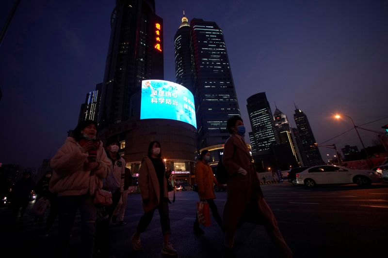 People wearing protective face masks are seen on a crossroads as the country is hit by an outbreak of the novel coronavirus, in Shanghai