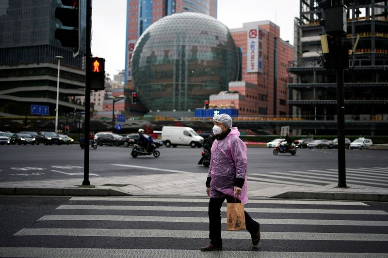 A man wearing a protective face mask is seen on a crossroads as the country is hit by an outbreak of the novel coronavirus, in Shanghai