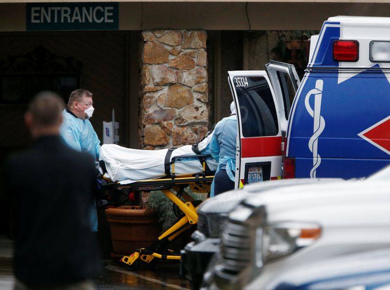 Medics load a person into an ambulance at the Life Care Center of Kirkland