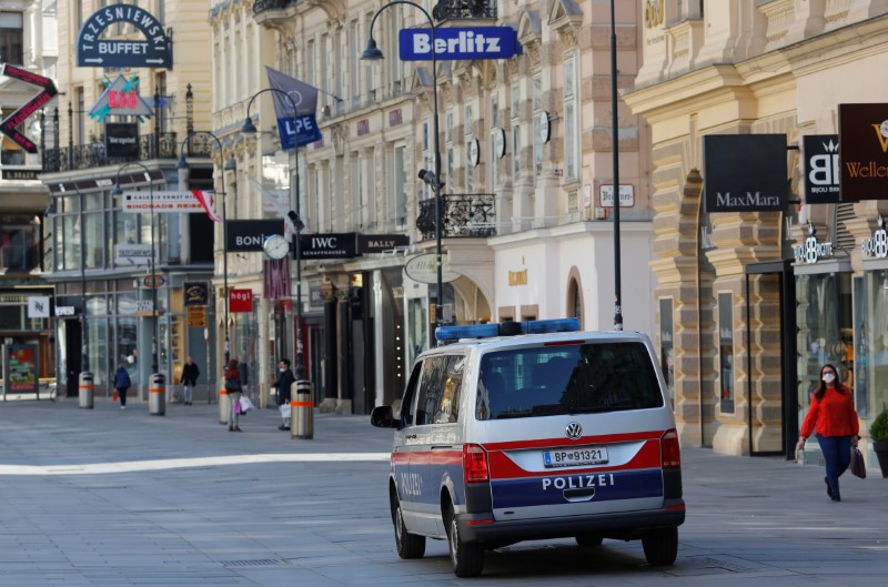 A police car drives next to closed shops in Vienna