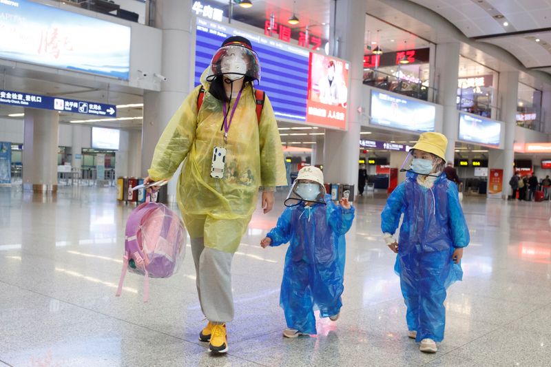 Passengers wearing face masks and raincoats walk through a nearly empty departure hall at Beijing Capital International Airport as the country is hit by an outbreak of the novel coronavirus