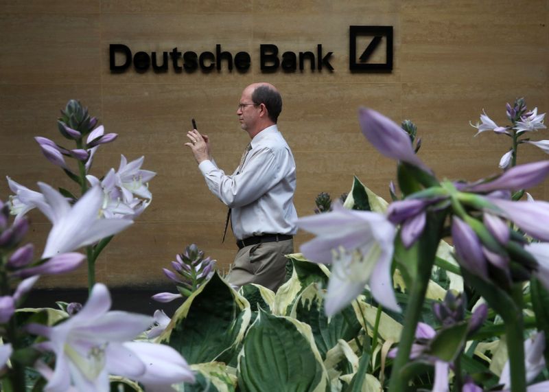 FILE PHOTO: A man walks past a Deutsche Bank office in London