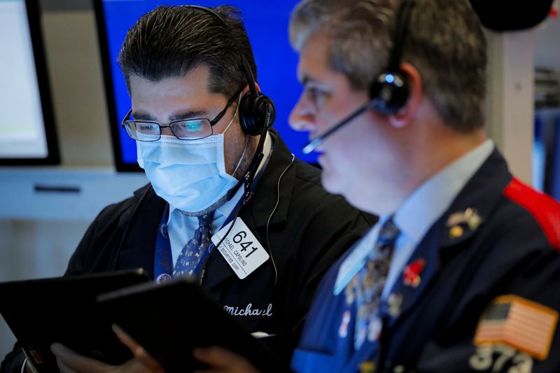 FILE PHOTO: Traders work on the floor of the NYSE in New York