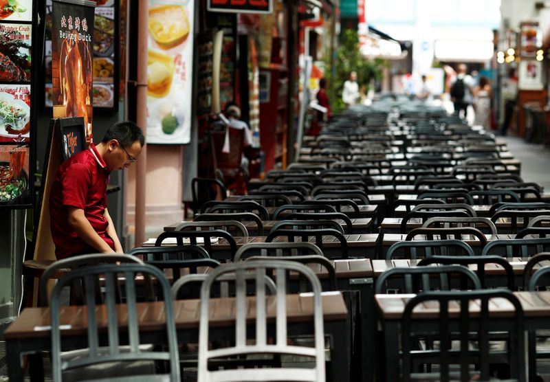 A restaurant promoter waits for customers at the largely empty Chinatown as tourism takes a decline due to the coronavirus outbreak in Singapore