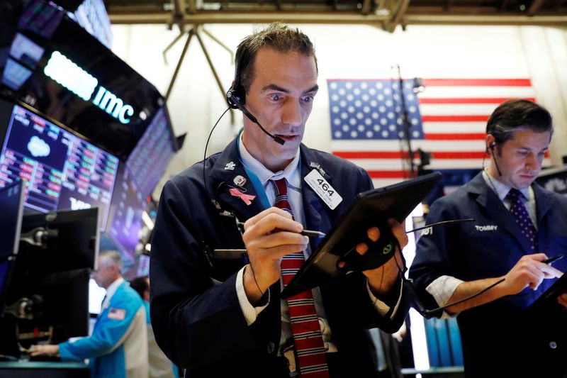 FILE PHOTO: A trader works on the floor at the New York Stock Exchange (NYSE) in New York City