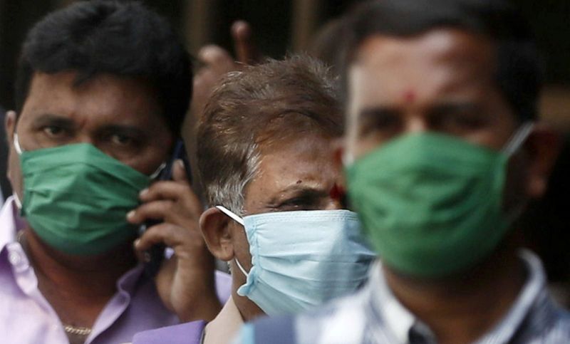 FILE PHOTO: Men wearing protective masks walk inside the premises of a hospital where a special ward has been set up for the coronavirus disease in Mumbai