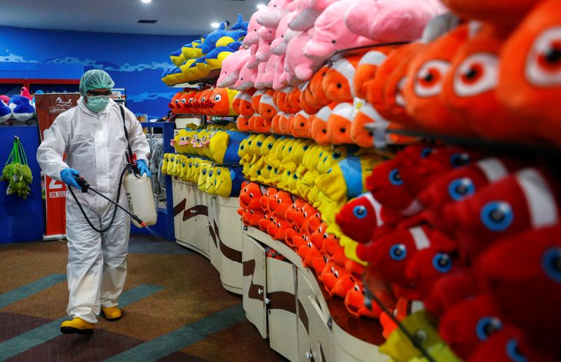 A worker wearing protective suit sprays disinfectant in Sea World, amid the coronavirus disease (COVID-19) outbreak, in Jakarta