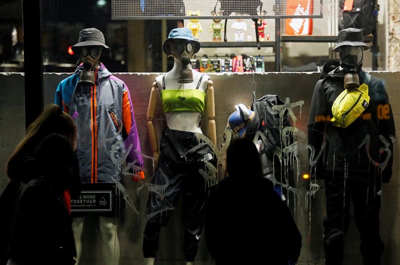 Mannequins wearing protective masks stand in a shop display window in Rome