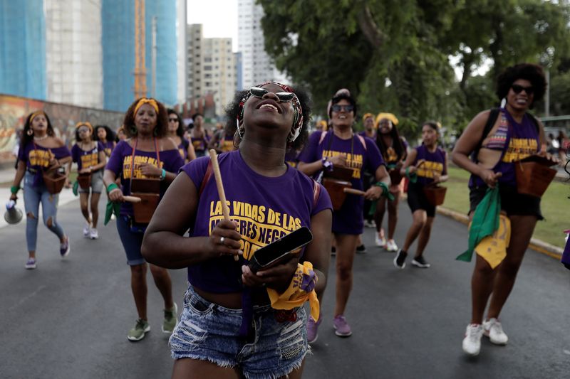 Women take part in a march to mark International Women's Day in Lima