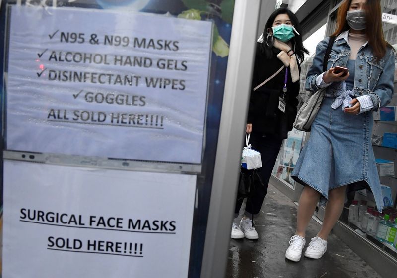 Customers wearing protective face masks are seen leaving a pharmacy in London