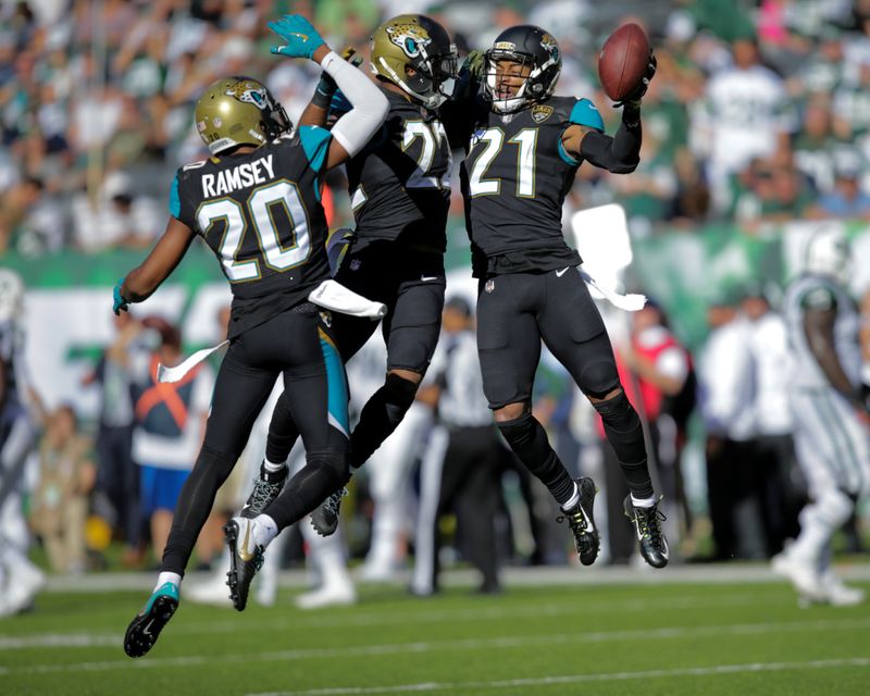 Jacksonville Jaguars players Jalen Ramsey, Aaron Colvin, and A.J. Bouye celebrate an intersection against New York Jets during their NFL football game in East Rutherford