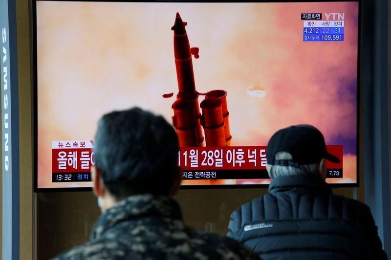 People watch a TV showing a file picture for a news report on North Korea firing two unidentified projectiles, in Seoul