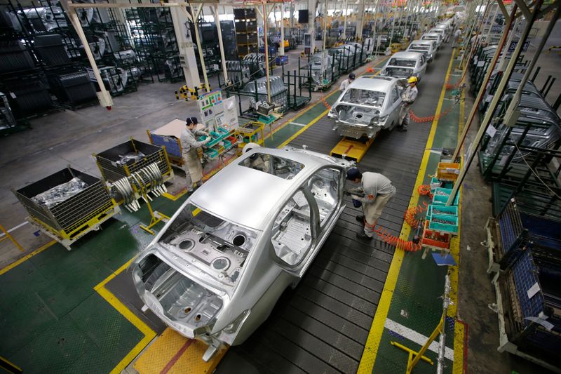 Employees assemble cars at a production line of Dongfeng Peugeot Citroen Automobile factory in Wuhan