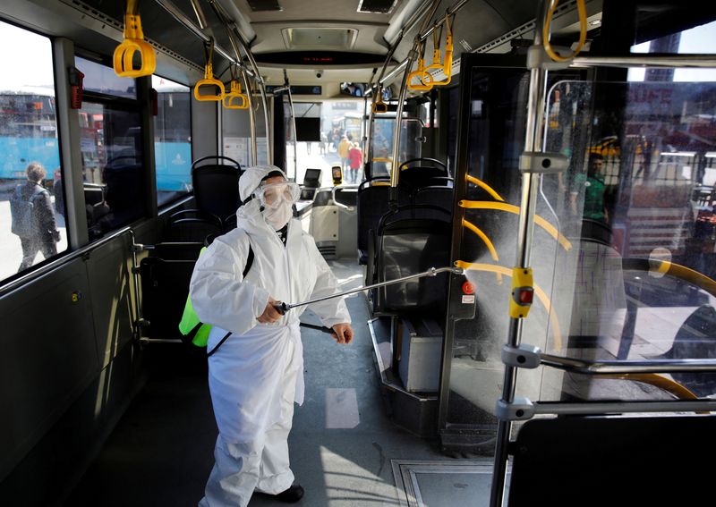 FILE PHOTO: A worker in a protective suit disinfects a bus due to coronavirus concerns in Istanbul