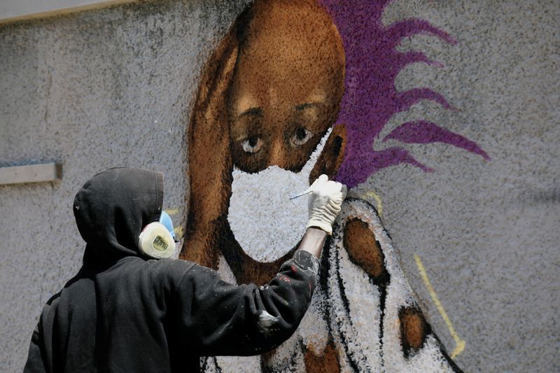 Serigne Boye aka Zeus, a graffiti artist from RBS crew works on his mural to encourage people to protect themselves amid the outbreak of the coronavirus disease (COVID-19), in Dakar