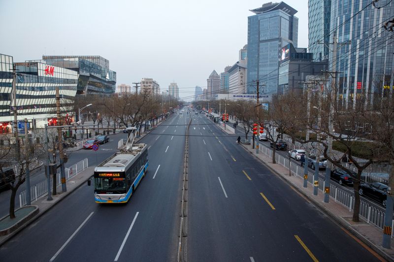 FILE PHOTO: A electric bus goes on a usually busy main road in the Sanlitun shopping district after the city emptied ahead of Chinese New Year in Beijing
