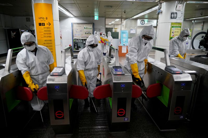 FILE PHOTO: Employees from a disinfection service company sanitise a subway station in Seoul