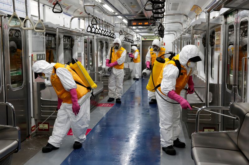 Employees from a disinfection service company sanitize a subway car depot in Seoul
