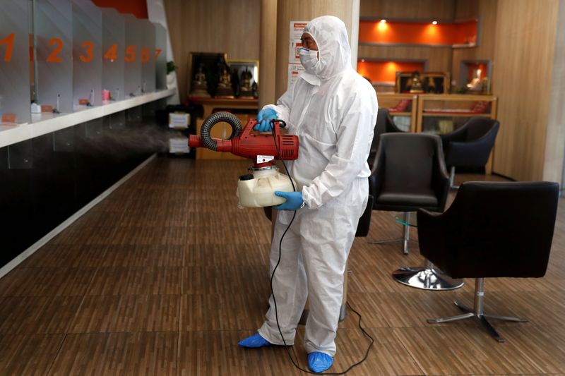 A man sprays disinfectant inside a currency exchange office as prevention after the coronavirus outbreak in Bangkok