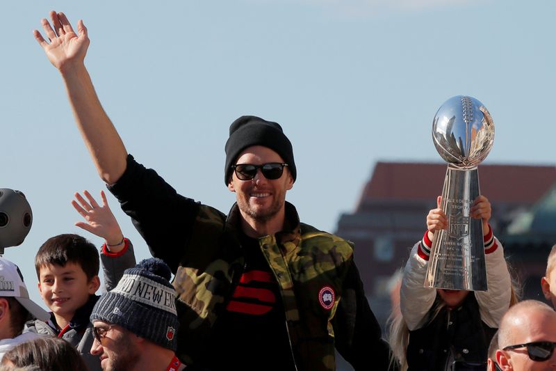 FILE PHOTO: New England Patriots quarterback Tom Brady waves as his daughter Vivian holds up a Lombardi trophy during a victory parade in Boston