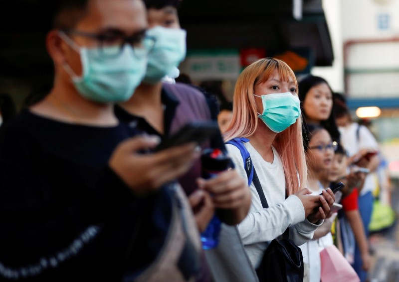 FILE PHOTO: Commuters wait for a transport to leave the Woodlands Causeway across to Singapore from Johor, hours before Malaysia imposes a lockdown on travel due to the coronavirus outbreak