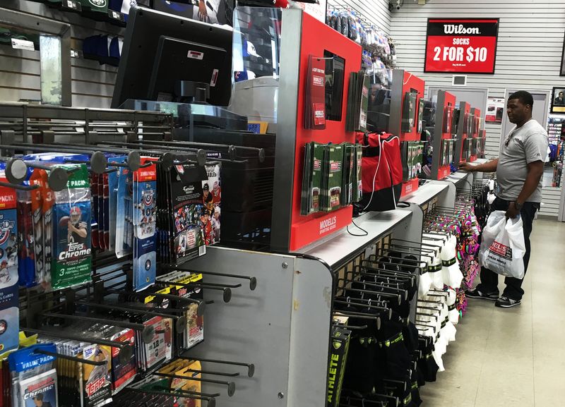 FILE PHOTO: A man waits to check out from shopping at a Modell's Sporting Goods store in New York