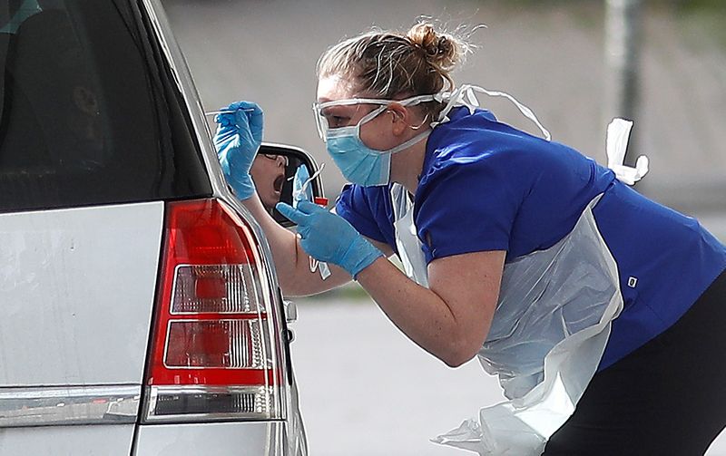 FILE PHOTO: Medical staff at an NHS drive through coronavirus disease (COVID-19) testing facility in the car park of Chessington World of Adventures