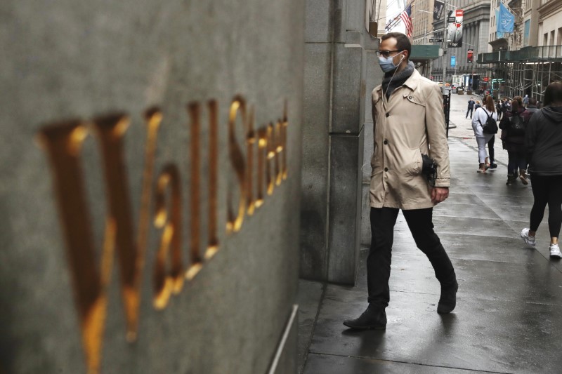 FILE PHOTO: FILE PHOTO: A man wears a protective mask as he walks on Wall Street during the coronavirus outbreak in New York