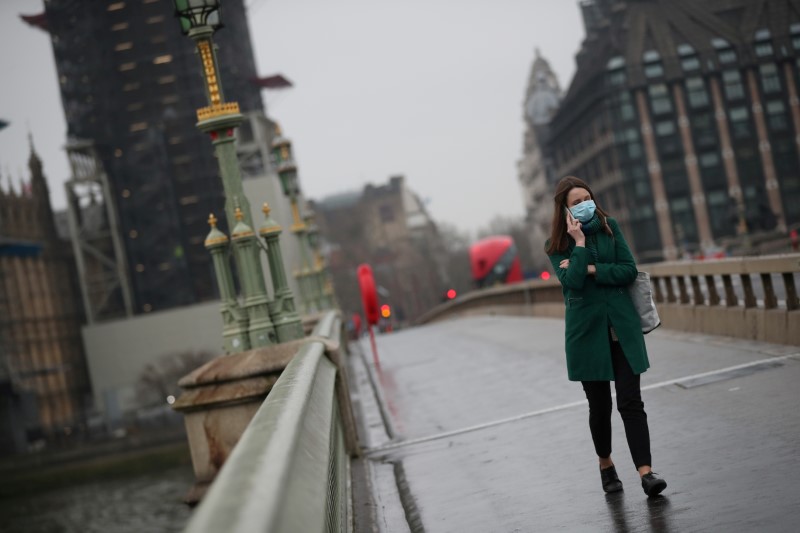 FILE PHOTO: A woman on Westminster bridge wearing a protective face mask