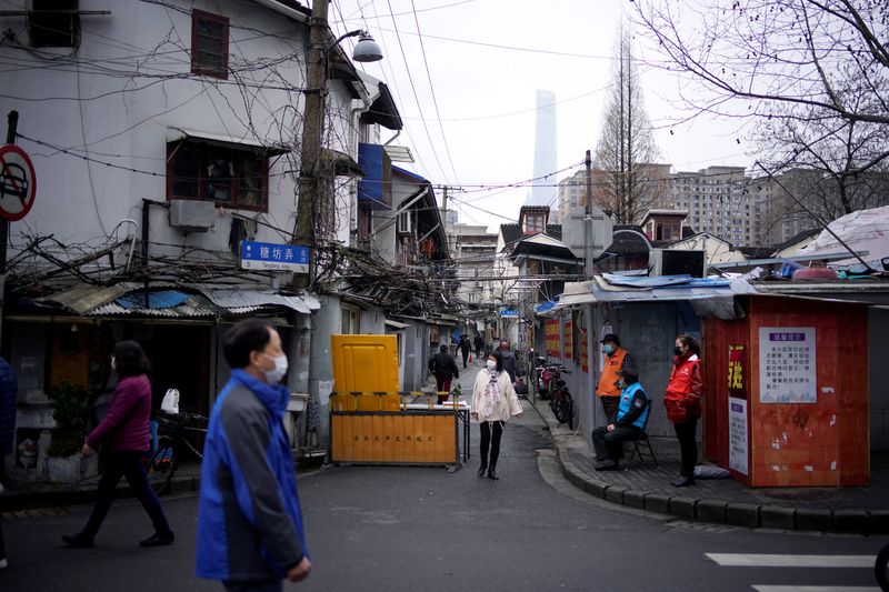 People wear protective face masks at a residential community following an outbreak of coronavirus (COVID-19), in downtown Shanghai