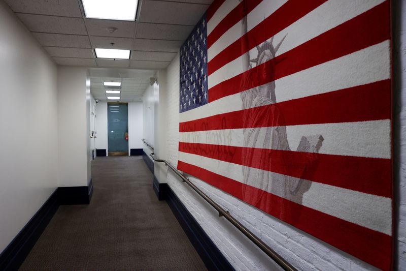 A hallway with a hanging rug of the U.S. flag at the U.S. Capitol is empty during the coronavirus disease (COVID-19) outbreak in Washington