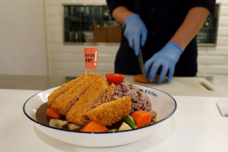 A pork cutlet dish made with plant-based meat Omnipork is displayed for the camera at vegan restaurant Kind Kitchen in Hong Kong