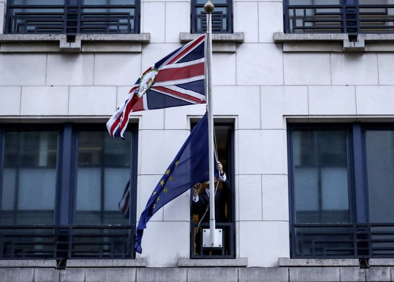 An official removes the EU flag from Britain's Permanent Representation to the EU in Brussels