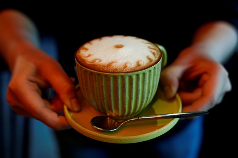 FILE PHOTO: A barista holds a cappuccino coffee at the La Tercera cafe in Beijing
