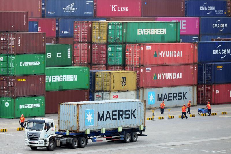 FILE PHOTO: Truck transports a container at a port in Qingdao, Shandong