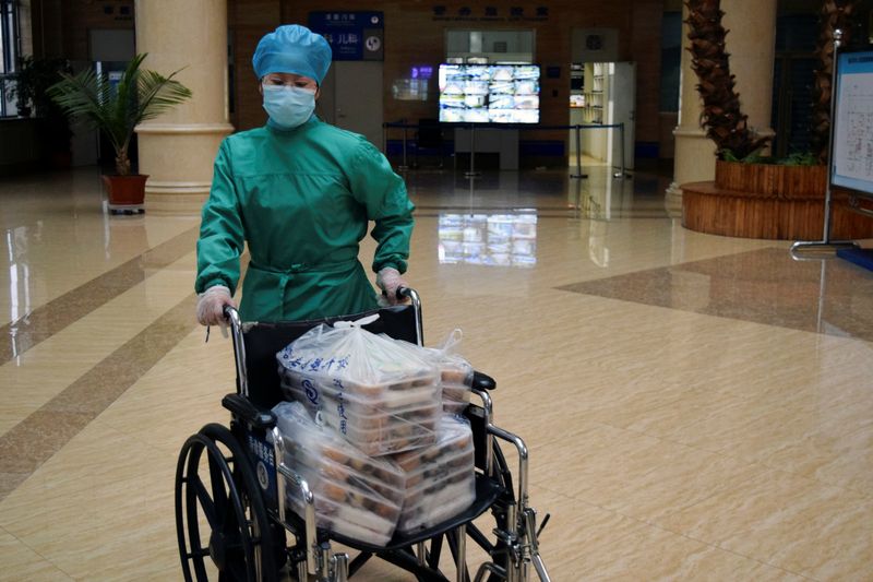 Medical worker moves food with a wheelchair at a hospital in Suifenhe