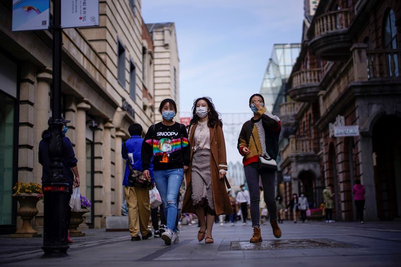 People wearing face masks are seen at a main shopping area after the lockdown was lifted in Wuhan