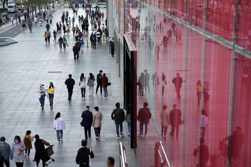 People wearing face masks are seen at a shopping area in Beijing