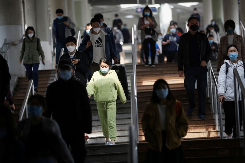 People wearing face masks walk inside a subway train during morning rush hour in Beijing, as the spread of the novel coronavirus disease (COVID-19) continues in the country