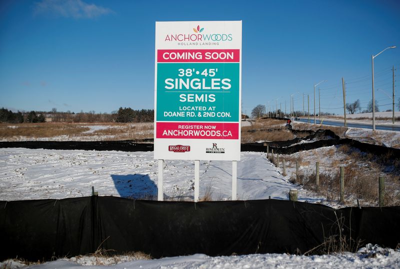 A sign advertising the sale of new homes stands in empty lot of land in East Gwillimbury