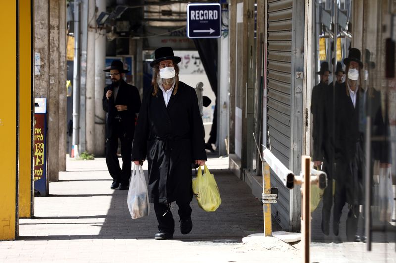 An ultra-Orthodox Jewish man wears a face mask while walking on a street in Bnei Brak as Israel enforces a lockdown of the ultra-Orthodox Jewish town badly affected by coronavirus disease (COVID-19), Bnei Brak