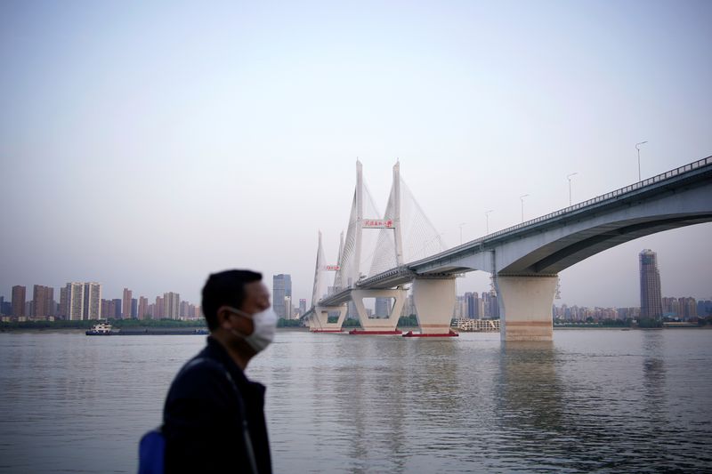 A man wearing a face mask is seen under a bridge of Yangtze river in Wuhan after the lockdown was lifted in Wuhan